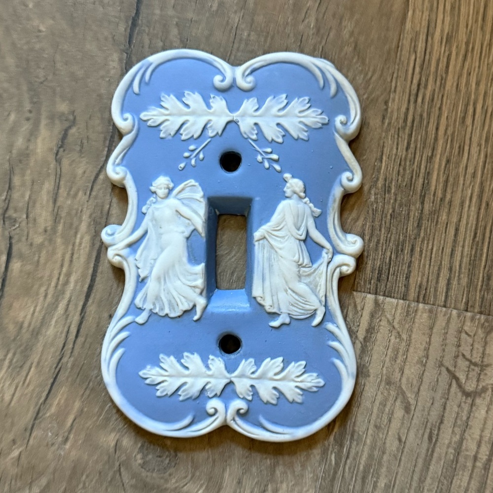 Ornamental ceramic light switch cover. Sky blue featuring Roman god & goddess.